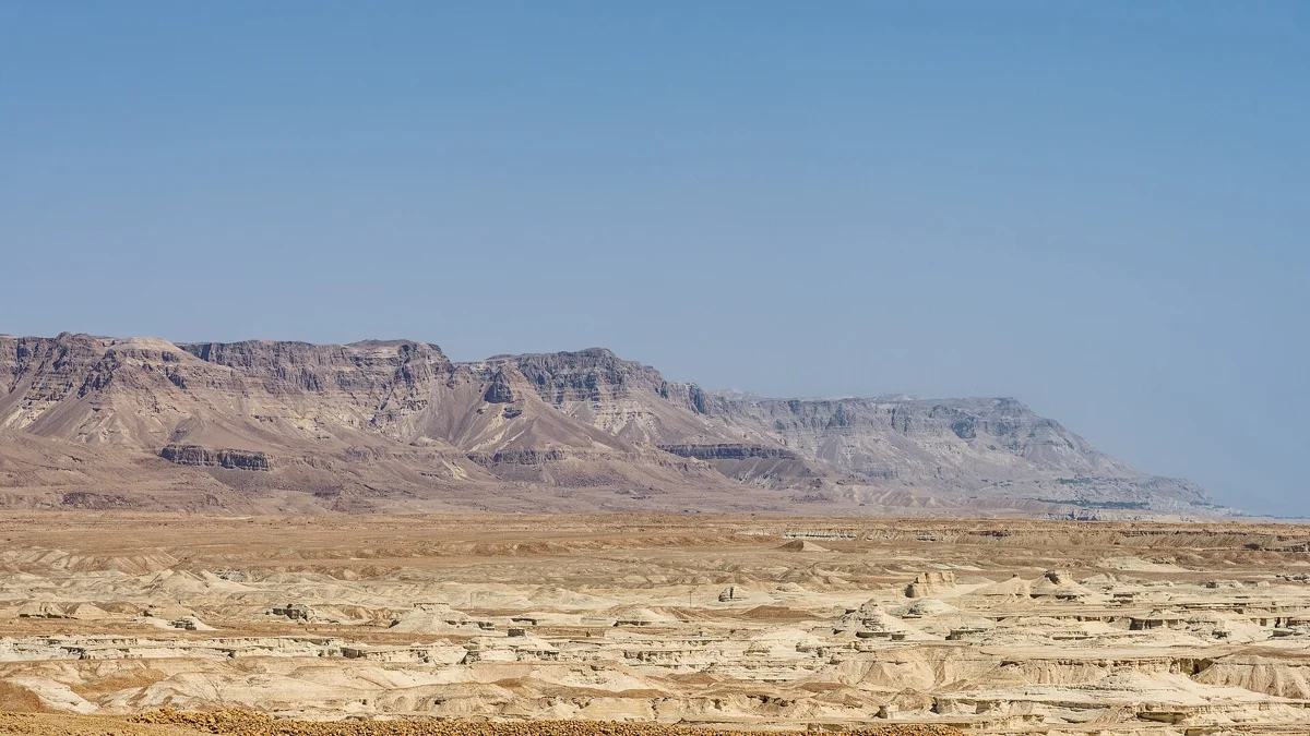 The receding Dead Sea shore under the desert cliffs on a Masada, Ein Gedi and Dead Sea tour
